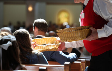 Collection baskets are passed at a Catholic Service