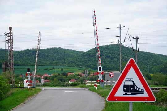 An open level crossing with barriers that allow the railroad tracks to be crossed. In a rural landscape near Alfeld, Lower Saxony, Germany.