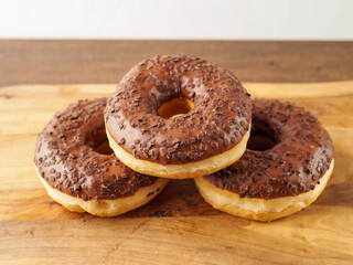 Sweet tasty chocolate donuts on wooden board. Popular desert and snack. Fine bakery product.