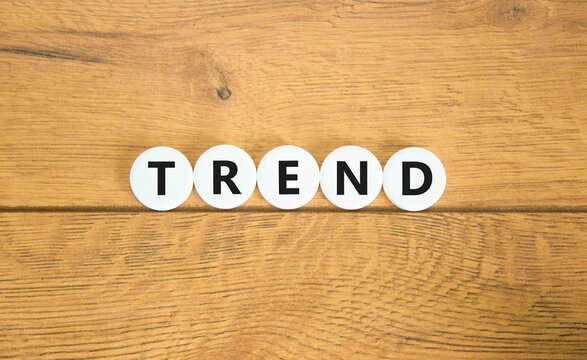 Trend and trending symbol. Concept word Trend on beautiful white circles. Beautiful wooden table wooden background. Business lifestyle trend and trending concept. Copy space.
