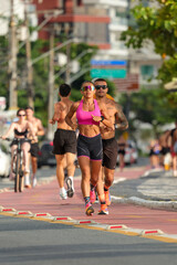 Runners Jogging on City Sidewalk with Urban Backdrop