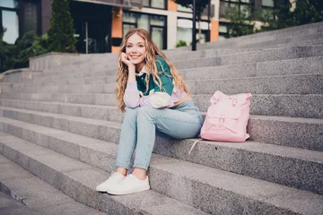 Gordijnen Full length portrait of pretty young girl sitting stairs smile city center outdoors © deagreez