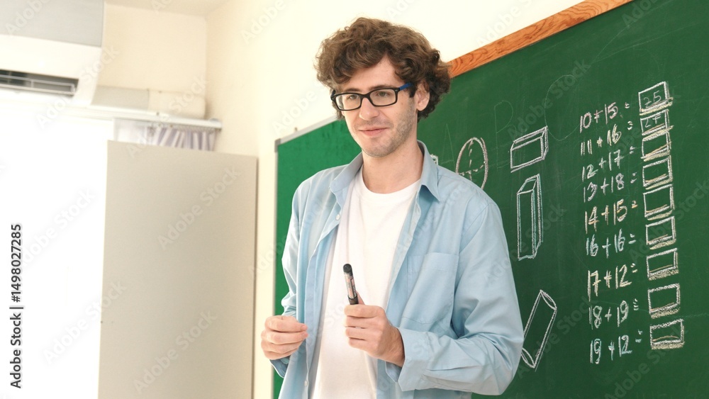 Poster caucasian teacher looking at student while standing at blackboard. low angle camera of professional 