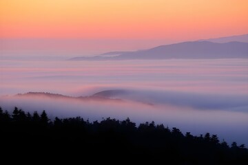 Obraz premium Beautiful morning mist and clouds reflecting the sunrise over the mountains and lake
