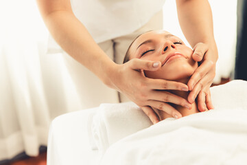 Caucasian woman enjoying relaxing anti-stress head massage and pampering facial beauty skin...