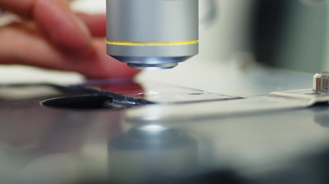 A scientist works with a microscope in the laboratory. Conducts research of biomaterial samples.