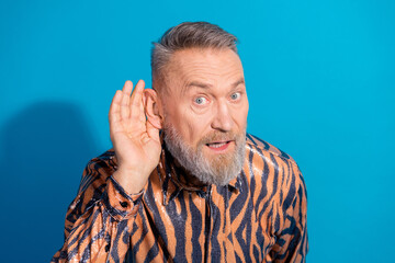 Excited Mature Man Gesturing With Hand Against Blue Backdrop in Stylish Printed Shirt