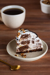 Piece of Pancho cake with pineapple and vegan sour cream topped with chocolate biscuit and walnut and cup of chicory. Homemade dessert. Sugar, lactose and gluten free. Vertical orientation.