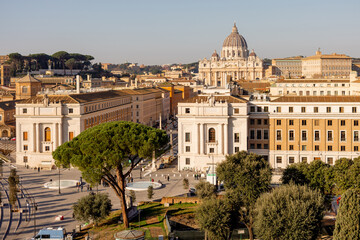 A sweeping view over Vatican City and St. Peters Basilica from Castel Sant Angelo, capturing the layout of Via della Conciliazione flanked by historic buildings and Roman pines