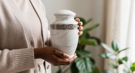 Woman holding elegant marble urn in indoor setting  