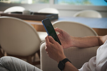 Person Using a Smartphone Indoors in a Minimalist Modern Setting