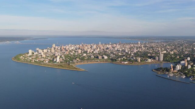 Expansive aerial panorama of Posadas, capital of Misiones, Argentina, with the winding Paran&aacute; River and the San Roque Gonz&aacute;lez Bridge in the background.