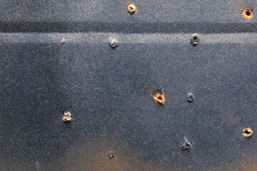 Closeup of black cardboard with holes
