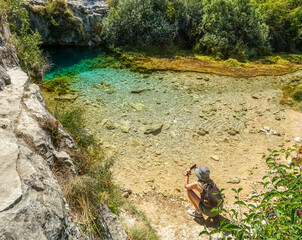 Young woman at the Pozo Azul, a spring or water source located in the Burgos town of Covanera (Spain), south of the Cantabrian mountain range in the Rudron Valley