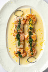 Portion of gourmet grilled shrimp skewers with sauce