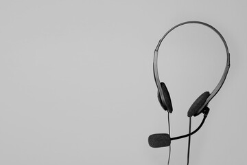 Headset with microphone in air on light grey background, space for text