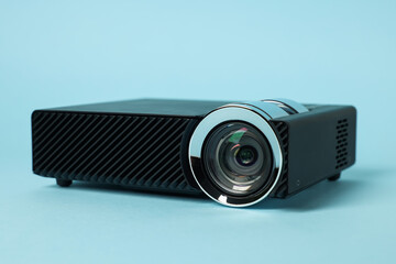 Modern video projector on light blue background, closeup