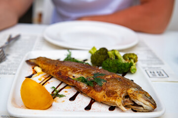 Roast trout with lemon and broccoli in the restaurant