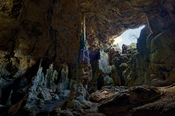 Dramatic interior of a natural cave in Spain, featuring striking stalagmites and stalactites.