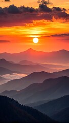 Obraz premium Fiery Sunset Over Layered Mountains with Clouds and Silhouettes
