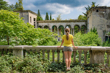 Lonely Girl in Bright Yellow Attire Standing Against Dilapidated, Abandoned Urban Structures
