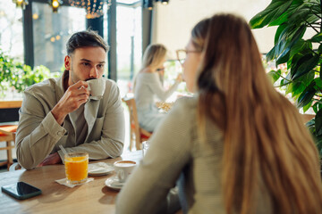 Young couple enjoying coffee and conversation in a cozy cafe
