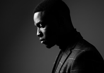 Sophisticated black and white portrait of a man in a blazer, focused and contemplative.