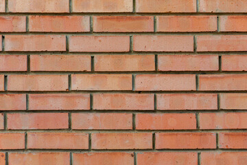 Close-up of a red brick wall with visible mortar lines, ideal for backgrounds, architectural designs, and construction-related visuals.