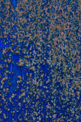 Close-up of a blue painted metal surface with scattered rust patches and corrosion, ideal for industrial, grunge, or textured backgrounds.