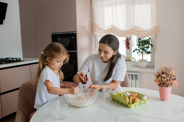 mom and two daughters in the kitchen cooking cookies