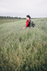 A young woman relaxes in the middle of a green meadow