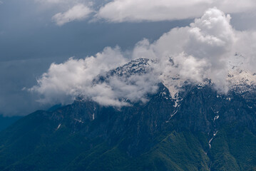 Dramatic, swirling clouds partly obscure the formidable limestone crags of Pizzo della Pieve, a distinct feature of the Grigna Settentrionale massif, Prealpi Lombarde, Italy