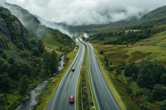 Stunning aerial view of the European route winding through lush landscapes under a cloudy sky, Aerial drone view of the European route E20 on a cloudy day Vertical
