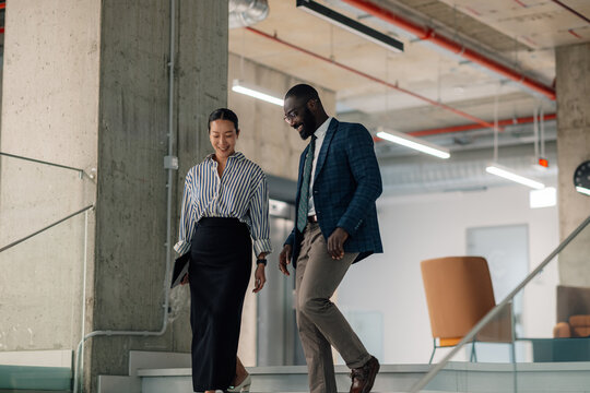 Business people walking down stairs in modern office building