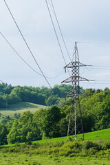 Landscape with electric distribution poles on a field in nature.