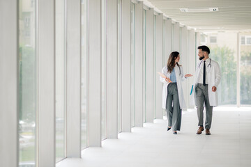 Doctors walking and discussing in hospital corridor