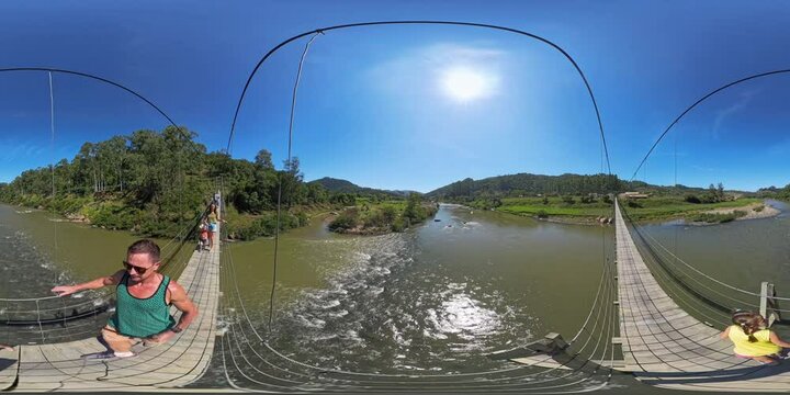 360 VR panorama of people walking on a hanging bridge over the rapid river in Brazil