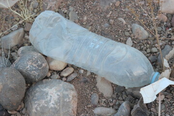 A plastic bottle lying on the ground, Environmental pollution	