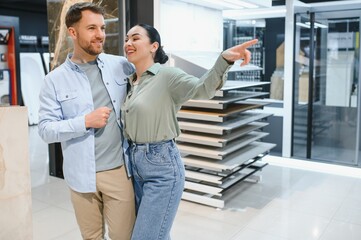 Fototapeta premium Couple choosing tiles in hardware store for home renovation project