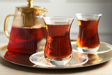 Tasty Turkish tea served on wooden table, closeup
