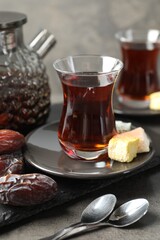 Tasty Turkish tea served with sweets on grey table, closeup