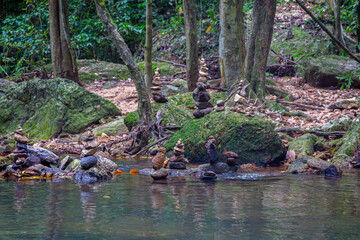 River leaving the Na mueang waterfall or Na muang 1 waterfall, Image shows the water stream after the waterfall passing between rocks with rock balancing also called stone balancing or stacking