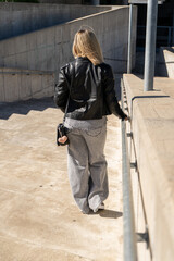 Blond woman walking down concrete stairs in urban setting