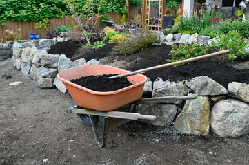 Landscape design project of stacked stone wall in progress in yard and garden