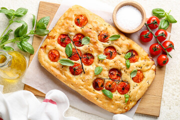 Delicious focaccia with tomatoes, spices and oil on beige table, flat lay