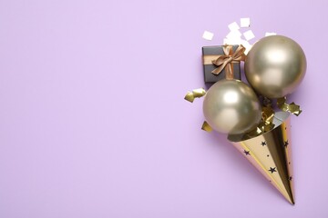 Beautiful party hat and other festive decor on violet background, flat lay. Space for text