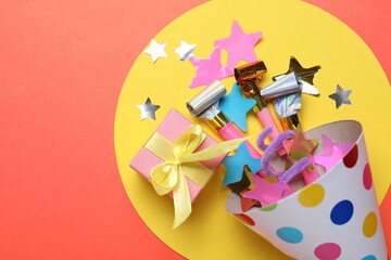Beautiful party hat and other festive decor on red background, flat lay. Space for text