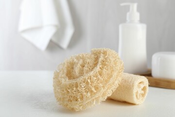 Different loofah sponges on white table, closeup
