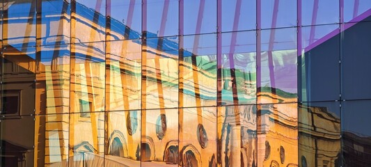 Gebäude spiegelt sich in bunter Glasfassade