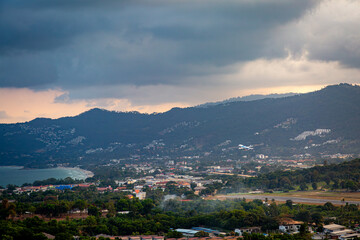 Ko Samui at sunset, Image shows sunset over the small island from the top of a mountain overlooking the airport, runway  and nearby town 